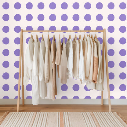 Bedroom headboard against a wall with lavender polka dots on a soft blush ground