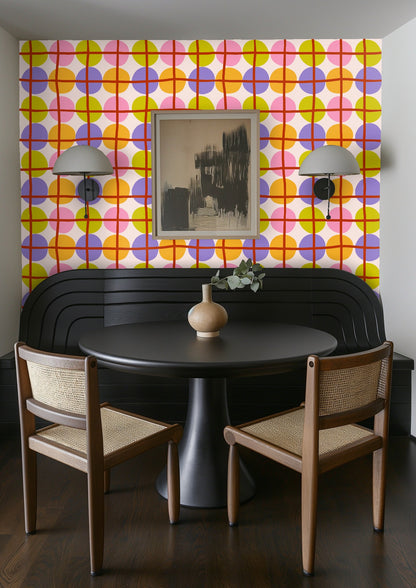 Full-wall installation showing the overall repeat of the colorful circle grid in a sunlit room with natural textures.