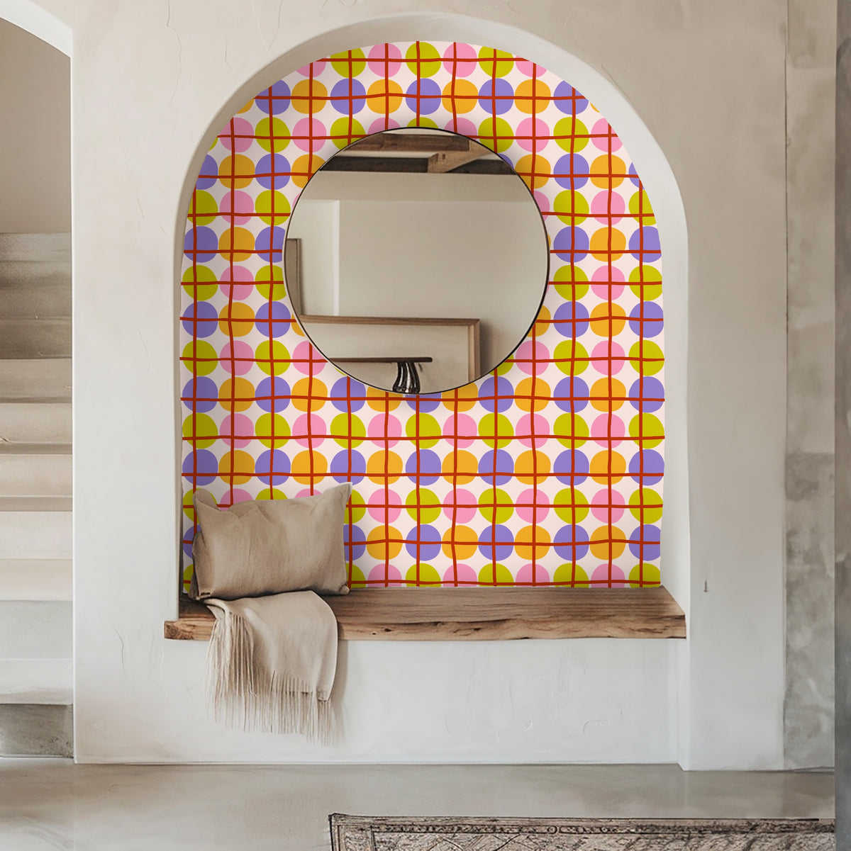 Living room view with a sofa in front of the colorful circle-and-grid wallpaper, showing how the repeat works across a lounge wall.