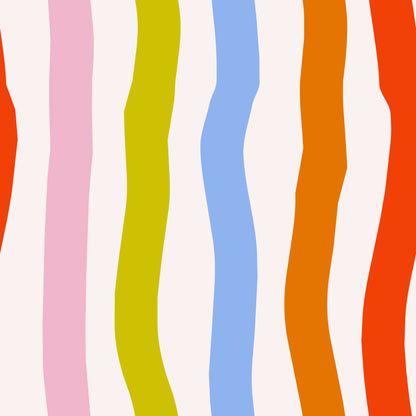 Portrait-style image of a model posed in front of the wallpaper to show human scale against the colorful wavy stripes